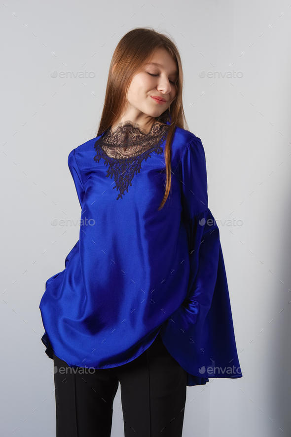 Attractive fashion model in blue silk blouse with butterfly sleeves