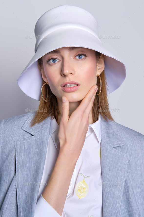 Gorgeous Lady In Cotton Jacket Slung Over Shoulders And Leather Hat Touching Her Chin Stock