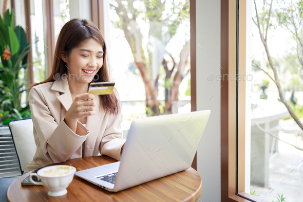Asian businesswoman using credit card for payments shopping online in laptop