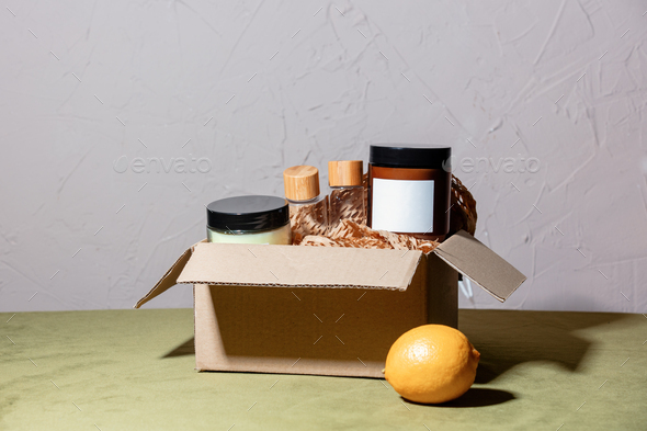 Cosmetics in carton box next to lemon on a table