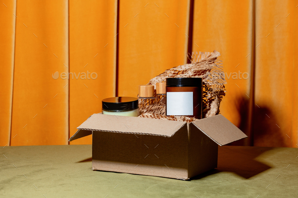 Cosmetics in carton box on a table with curtains on background