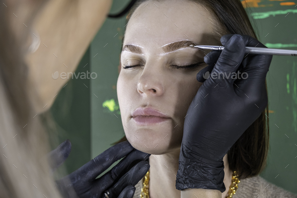 eyebrow painting styling, correction, coloring and lamination procedure in a beauty salon