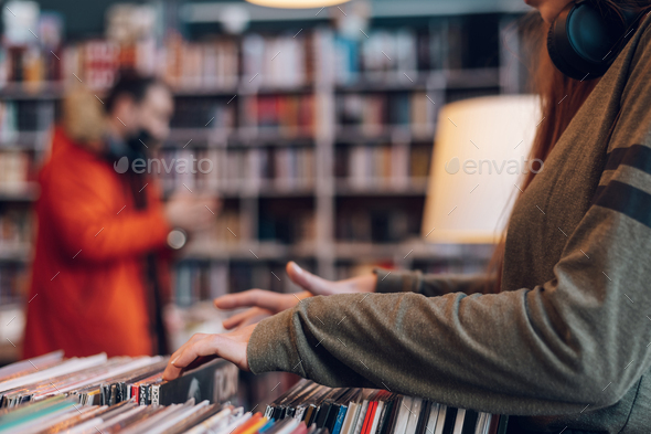 Woman hands choosing vinyl record in music record shop