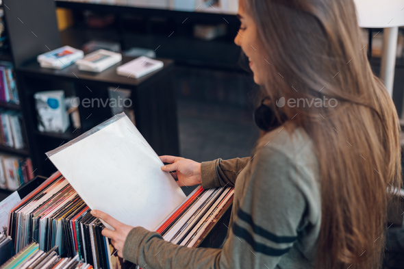 Woman hands choosing vinyl record in music record shop