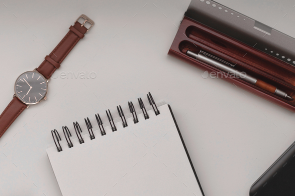 Open notebook with a pen and a laptop in a white background