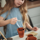 Little Girl Sowing Seeds Into Flower Pots - PhotoDune Item for Sale