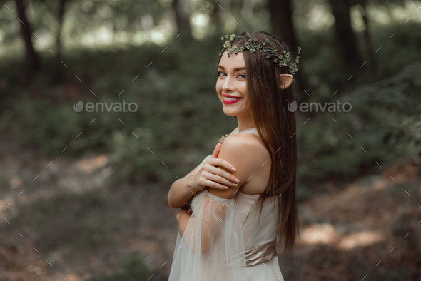 smiling girl with elf ears and with floral wreath on head