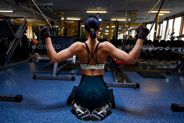 Athletic woman in the gym showing muscles - Stock Photo - Images