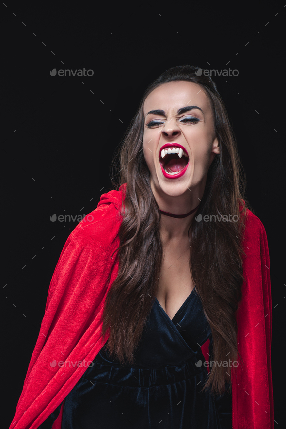 mystic vampire woman in red cloak showing her teeth isolated on black ...
