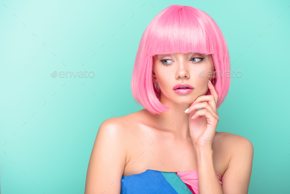 thoughtful young woman with pink bob cut looking away isolated on turquoise