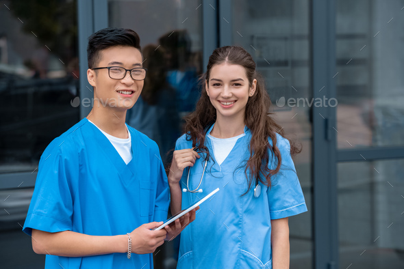 multicultural medical students holding tablet and looking at camera at medical university