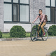 asian young man with backpack riding bicycle on street - PhotoDune Item for Sale