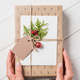 cropped image of woman with decorated christmas gift box at wooden table - PhotoDune Item for Sale