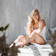 selective focus of attractive blonde girl in underwear sitting on bed and smiling at camera - PhotoDune Item for Sale