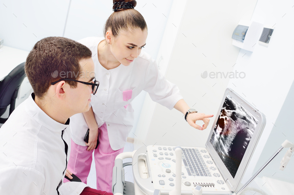 young doctors examine and discuss the result of ultrasound of the thyroid gland