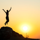 Silhouette of woman hiker jumping alone on empty rock at sunset in mountains - PhotoDune Item for Sale