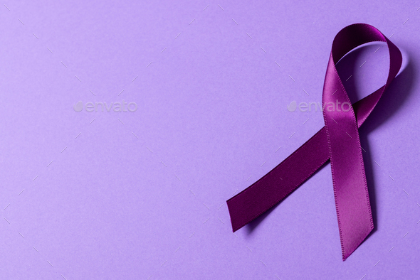 High angle view of purple awareness ribbon isolated against purple background, copy space
