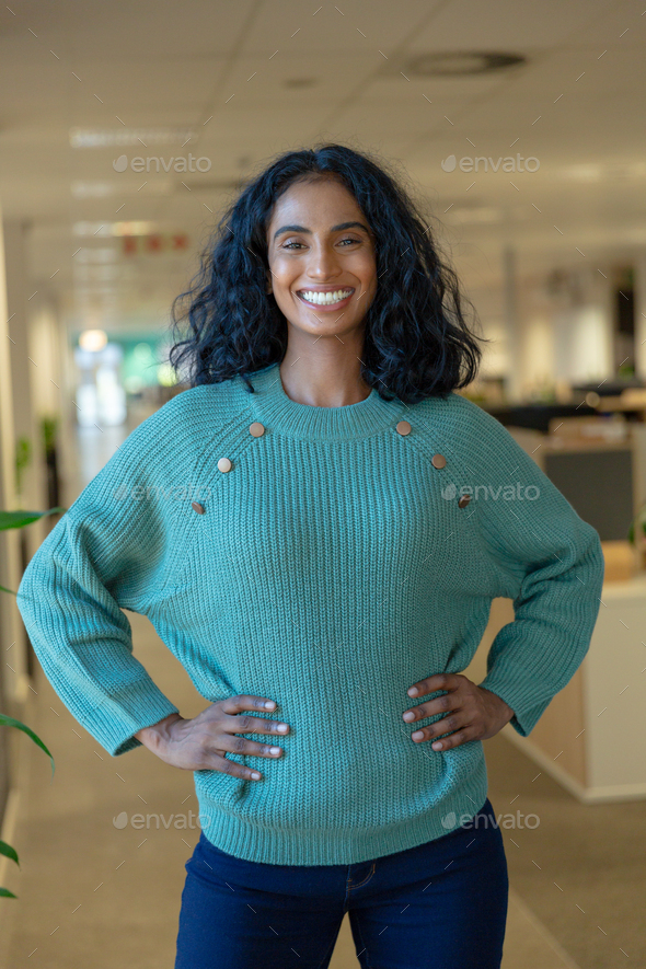 Portrait Of Happy Biracial Female Advisor Standing With Hands On Hips