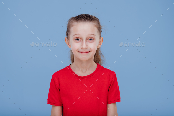 Funny surprised little girl in red t shirt staring at camera
