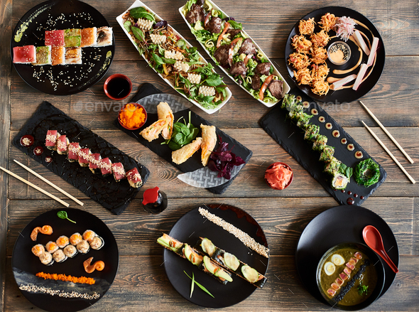 Serving sushi rolls and other traditional japanese and asian food on a table