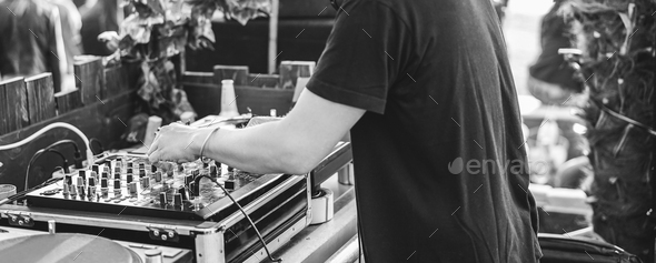 Dj playing music at cocktail bar outdoor - Focus on left hand - Black and white editing