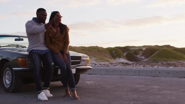 African american couple pointing towards a direction while standing on the road alt