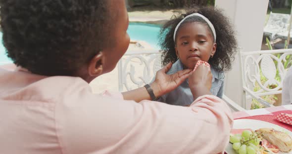 Happy family eating together at table alt