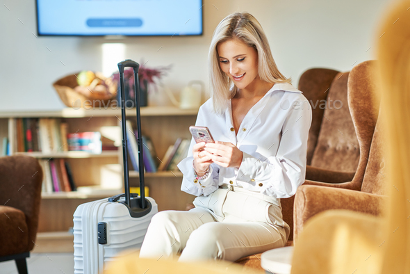 Businesswoman with luggage in modern hotel lobby