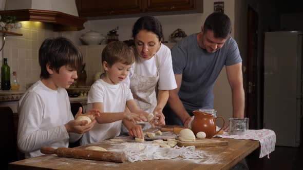 Children Helping Parents to Preparing a Dough in Domestic Kitchen