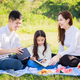 Happy family picnic. Asian parents, little girl reading book and enjoyed on picnic cloth - PhotoDune Item for Sale