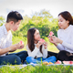 Asian parents (Father, Mother) and little girl eating watermelon together during picnic - PhotoDune Item for Sale
