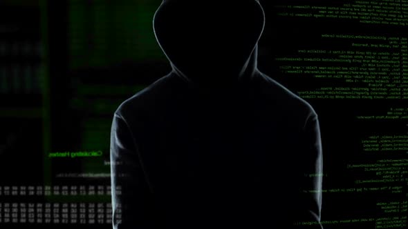 Male Hacker With Handcuffs Standing in Front of Animated Computer Code, IT Thief alt