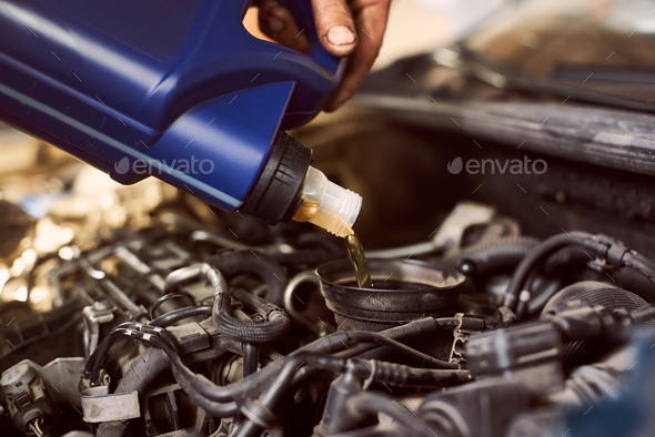 Engine oil changing and maintenance gear car engine in auto service workshop.