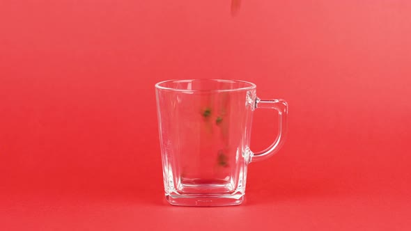 Coffee Beans Quickly Fly, Transparent Glass Cup, Red Background. Morning Concept alt