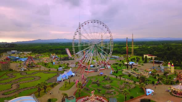 Top view of amusement park with Ferris wheel and roller coaster alt