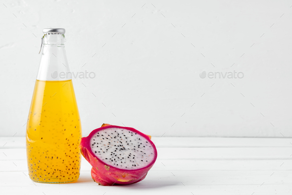 Glass bottle of dragon fruit drink on white background