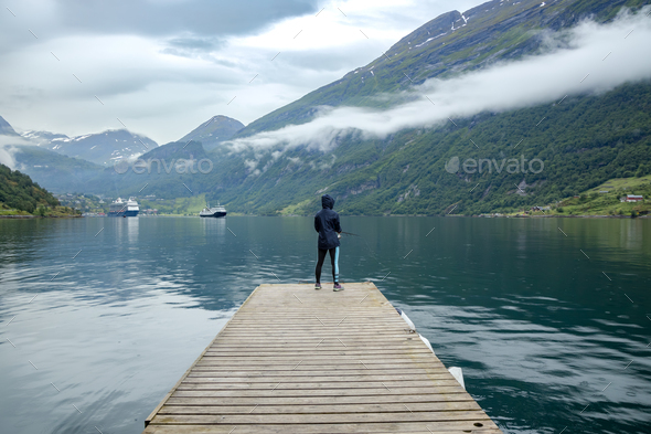 Woman fishing on Fishing rod spinning in Norway. Stock Photo by