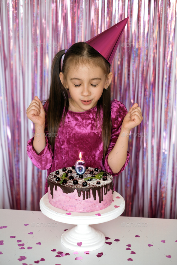Girl makes a wish before blowing out the candle on the cake