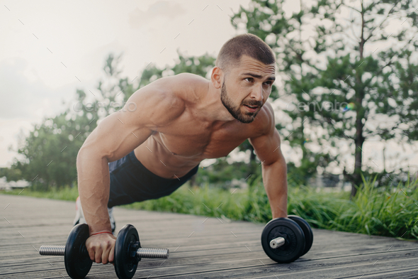 Muscular Male Bodybuilder Does Push Up With Barbells Stands In Plank Pose With Naked Body Stock