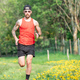 Young athlete with tattoo on arm runs through a meadow - PhotoDune Item for Sale