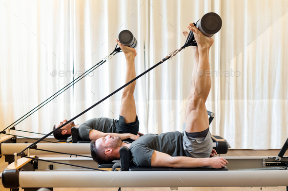 Men working out in a gym doing Pilates hip mobility exercises Stock Photo  by Photology75