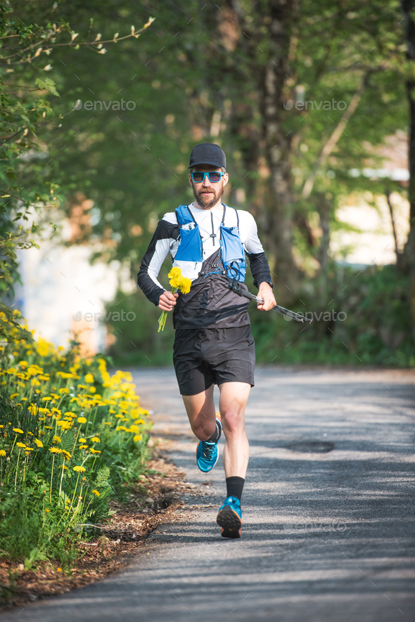 Athlete running with yellow flowers in hand - Stock Photo - Images