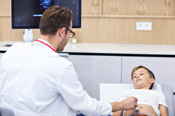 Doctor testing young boy with usg - Stock Photo - Images