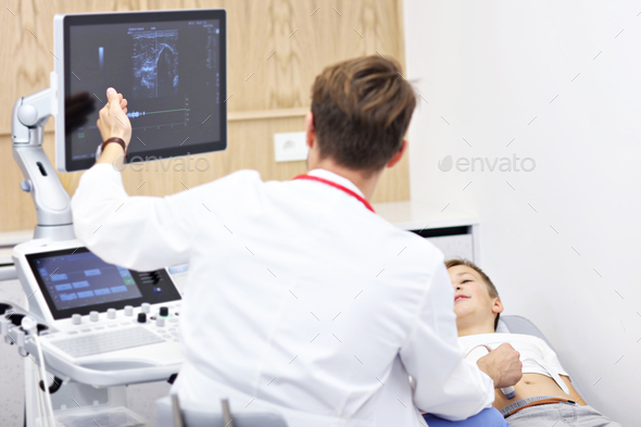 Doctor testing young boy with usg - Stock Photo - Images