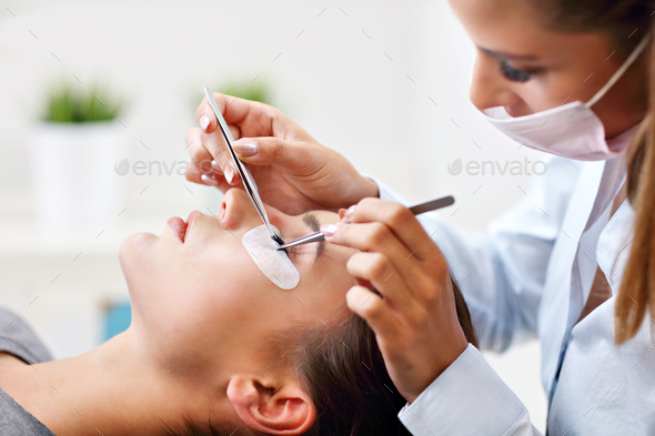 Adult woman having eyelash extension in professional beauty salon