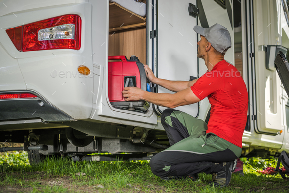 Men Removing Portable Gas Generator From His Camper Van RV Storage Area
