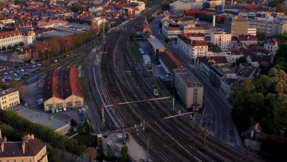 Europe train entering city on tracks drone follow shot at golden hour 4k 30p alt