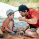 Father with son eating salad on beach - PhotoDune Item for Sale