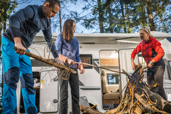 Friends Hanging Out Around Campfire Next to Their Motorhome RV - Stock Photo - Images