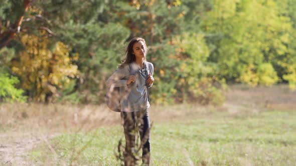 Carefree Hipster Woman Walking in Meadow Along Forest, alt